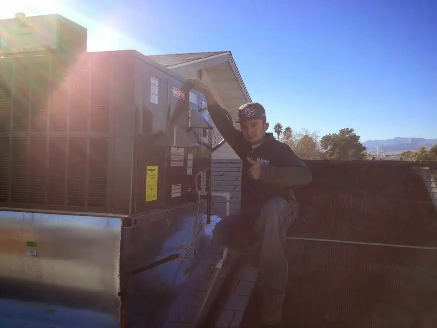 HVAC technician performing Air Duct Cleaning on a rooftop unit in Trinity